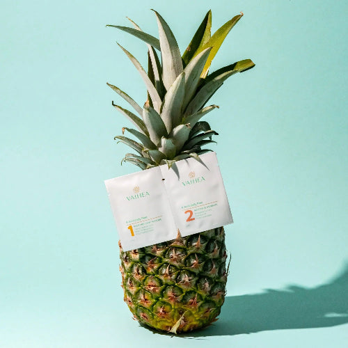Pineapple with Vaidika skincare products attached on a light blue background