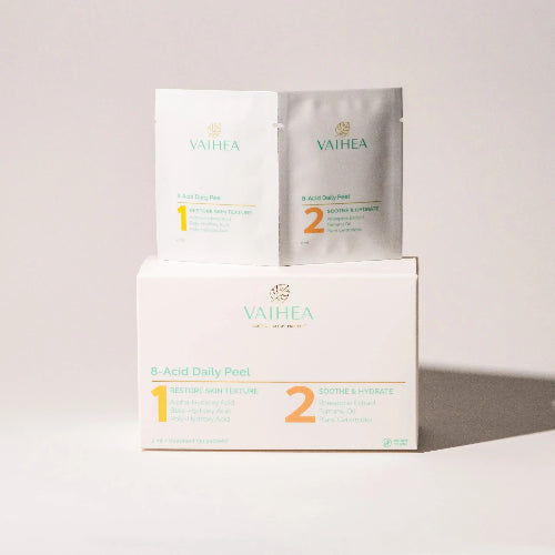 Vaihea skincare products including a box, packets, and a sheet on a light gray background
