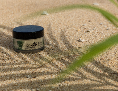 Jar of cream on sand with a blurred background