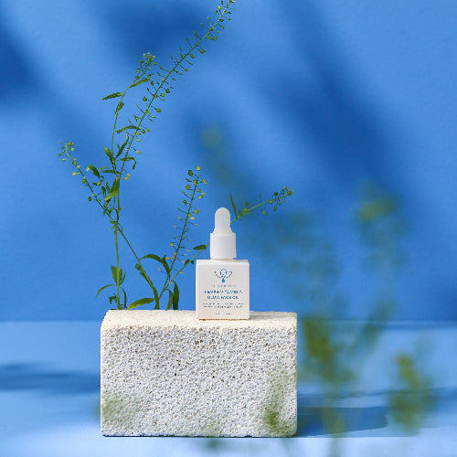 bottle of olecea hemp oil on white stone with blue background