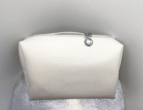 A white, crosshatched, patterned travel-size cosmetic bag with a water-resistant exterior and an easy-to-clean interior.
