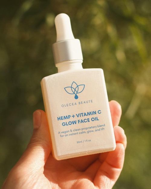 A bottle of Hemp + Vitamin C Glow Face Oil by Olecea with a dropper, labeled for skincare use.