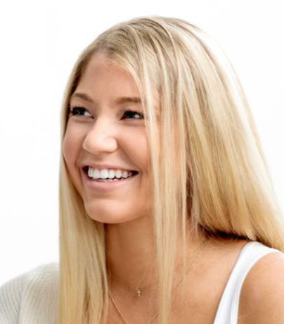 Woman with long blonde hair smiling on a white background