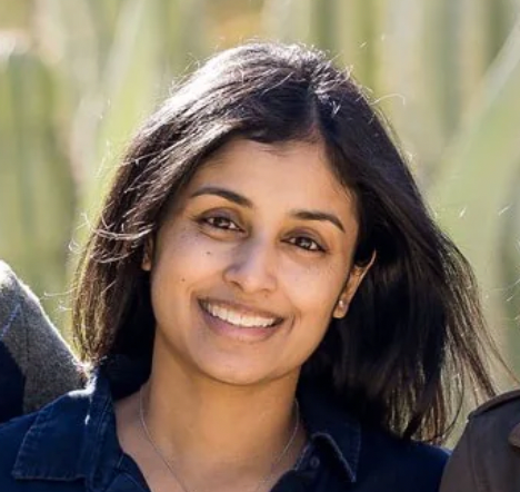 Gita standing outdoors with greenery in the background