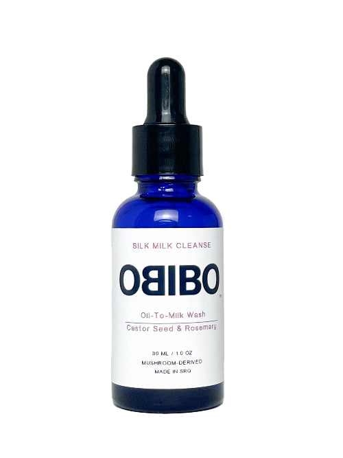 A 30 mL cobalt blue glass dropper bottle of OBIBO Silk Milk Cleanse Oil-to-Milk Wash, featuring a white label with bold navy text and a black dropper cap, set against a plain white background.