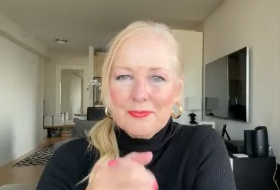 Karen in a black turtleneck sitting in a living room.