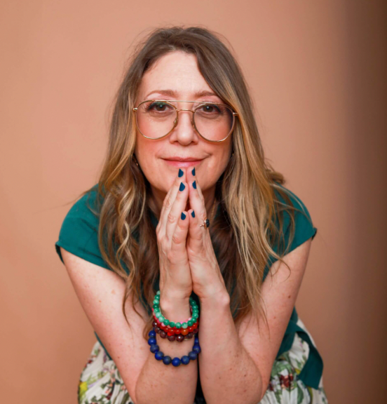 Woman with glasses and colorful bracelets on a brown background