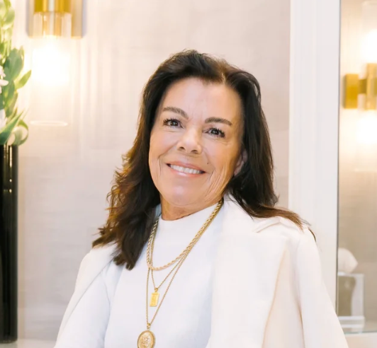 LeiLani in a white outfit with gold jewelry in an indoor setting