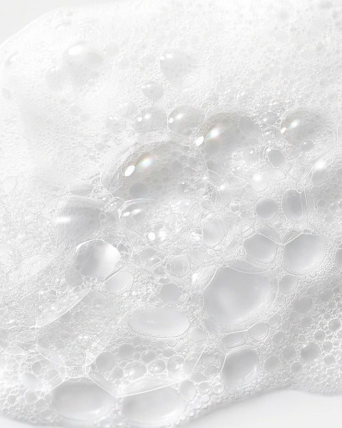Close-up of white foam with bubbles on a white background