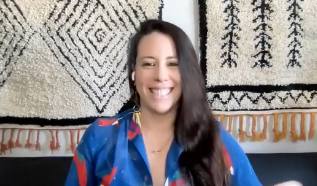 Woman smiling in front of decorative wall hangings