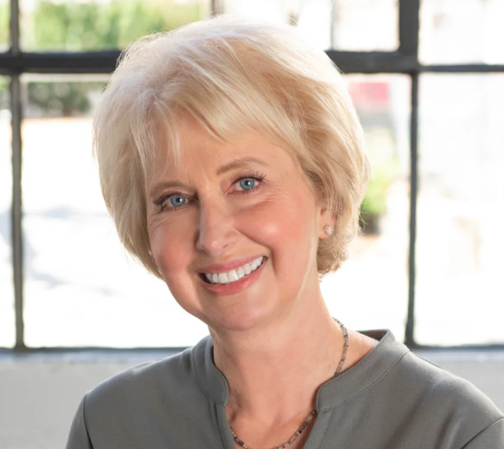 Olga smiling in front of a window.