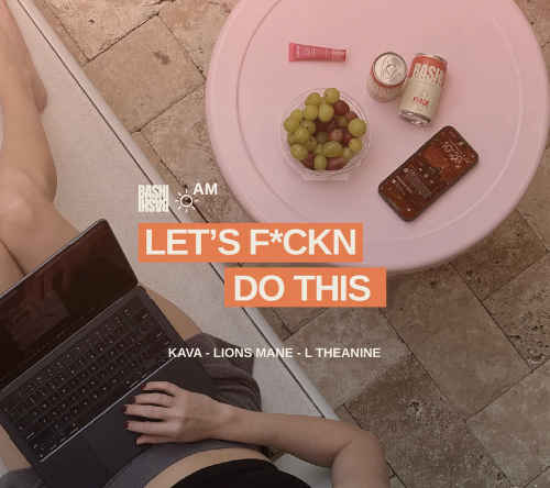 Bashi can on table with grape and cell phone while woman works on her computer