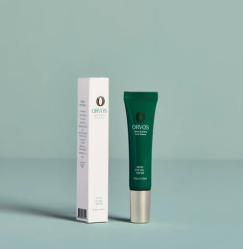 Orvos eye cream shown with its white rectangular packaging box and a dark green squeeze tube with a silver cap, set against a solid pale blue-green background.