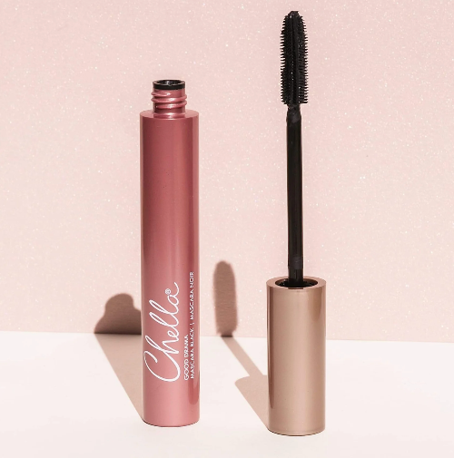 Chella mascara shown with the open tube and wand brush against a sparkly pink background.