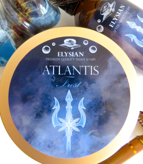A round tin of Elysian Atlantis Frost premium quality shave soaps, featuring a blue and white watercolor design with a trident graphic and a gold-colored rim.
