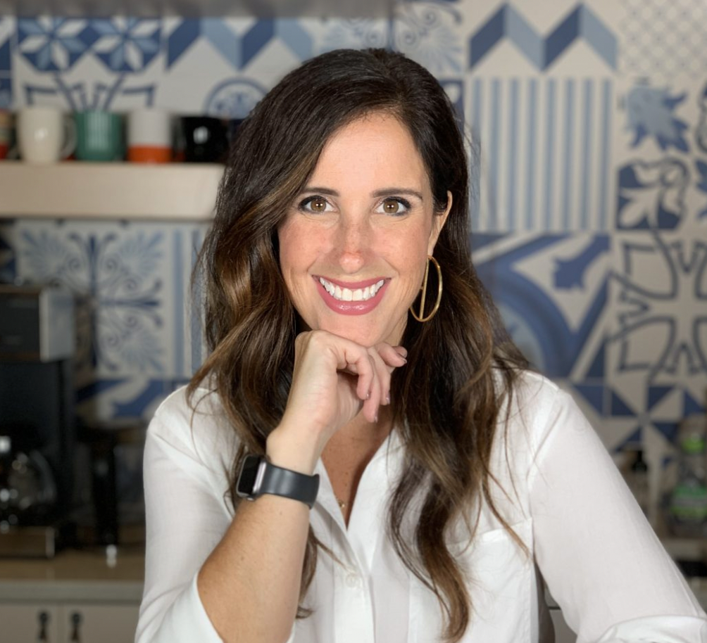 Stefanie in a white shirt with a decorative blue and white tile background