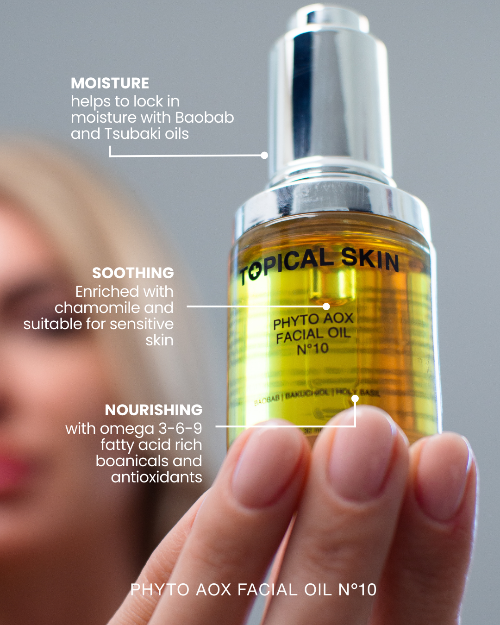 Topical Skin Phyto AOX Facial Oil bottle held by a hand with product features highlighted.